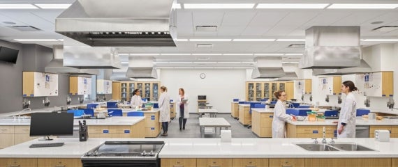 Students wearing lab coats working in a food science lab at Brescia University College Academic Pavilion