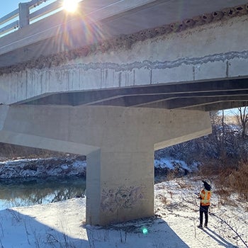 bridge inspector looking up at bridge from ground