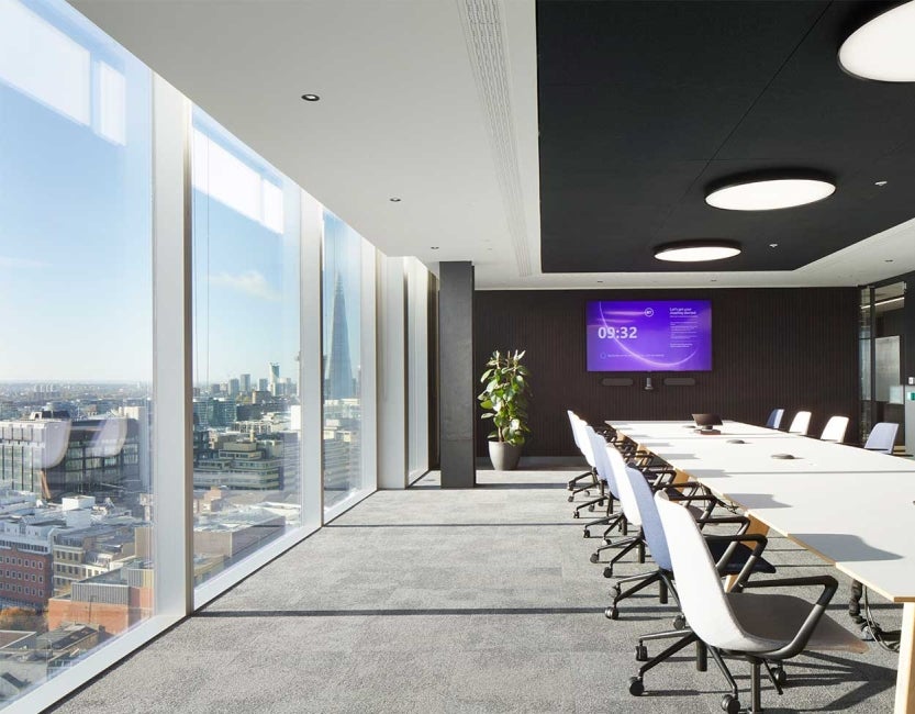 Meeting room at One Braham, London, UK. A desk with a row of chairs. 