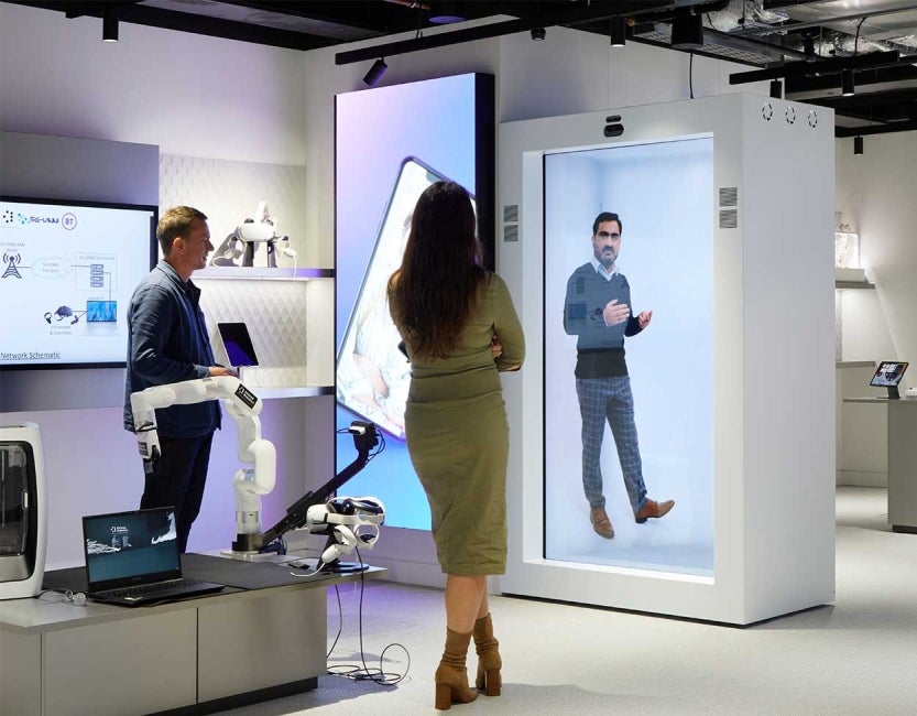 Man and woman looking at hologram projected onto wall at One Braham, London, UK.