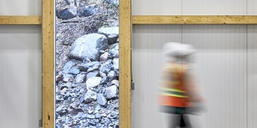 interior image of canadian nuclear lab warehouse with person in construction vest and hard hat walking in the foreground