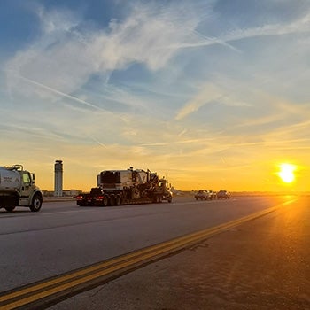 Vehicles on Columbus taxiway at sunset