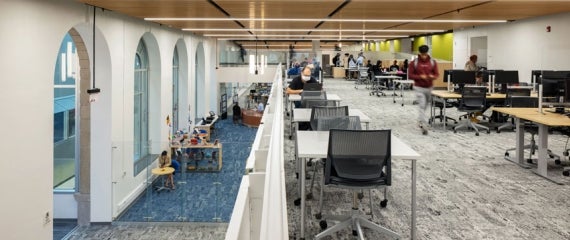 A view from the second floor looking down and out at students studying on two floors of the Community College of Philadelphia Library Learning Commons.