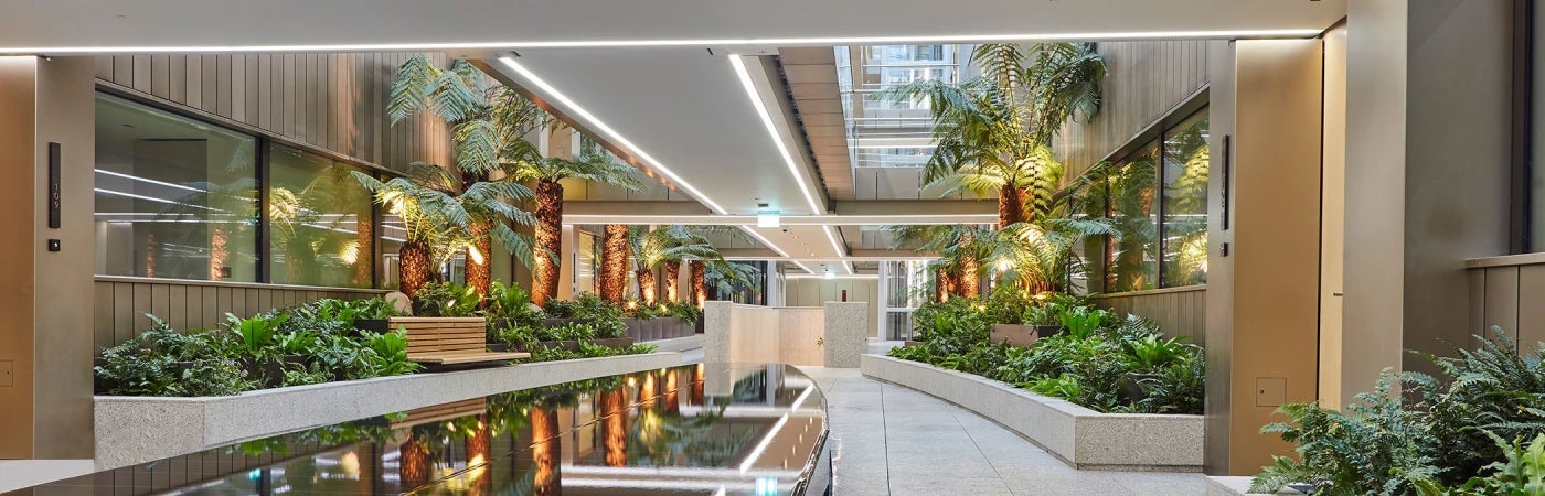 interior view of Marylebone Square with ample lighting and lush vegetation aside indoor water feature