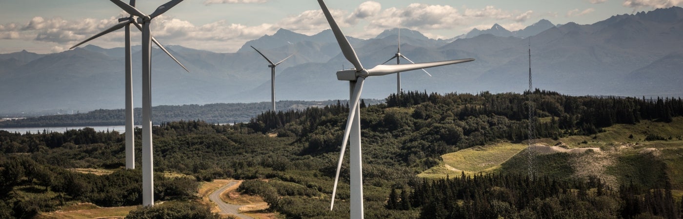 aerial of wind energy farm turbines against landscape creating renewable energy