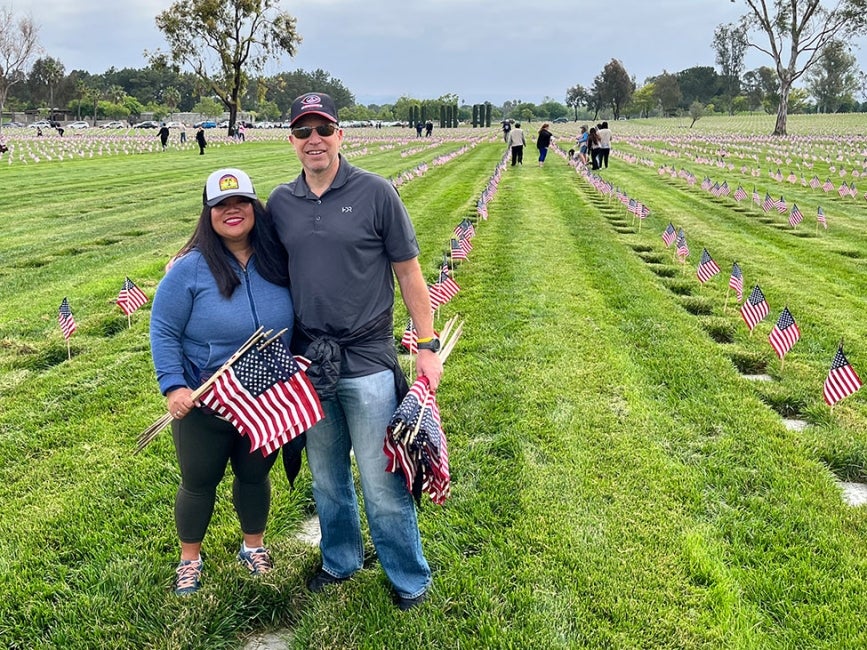 Two employees brining flags to veterans' graves on Memorial Day