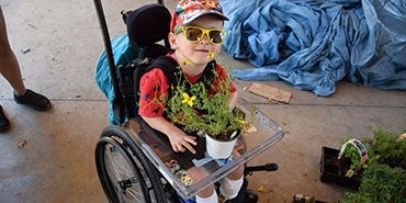 A boy using a wheelchair at a community garden