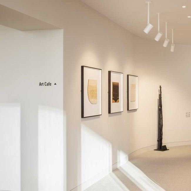 Interior of 22 Bishopsgate, London. Next to the bottom of a flight of stairs. A kitchen area can be seen at the baclk.