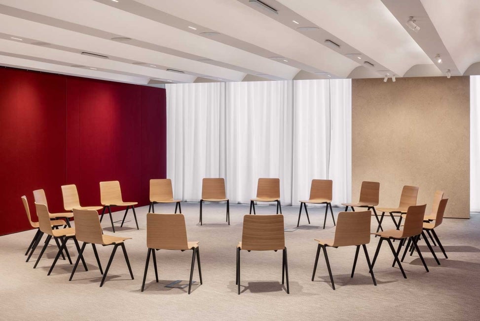 Interior of meeting room at 22 Bishopsgate, London with wooden chairs assembled in a circle.