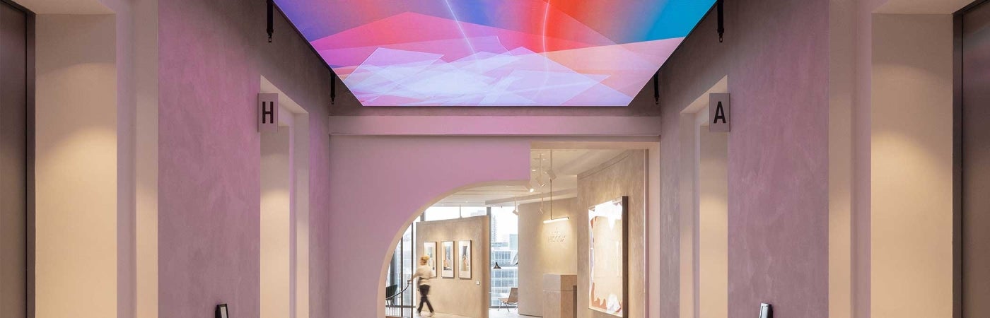 Hallway at 22 Bishopsgate, London. A large colorful digital display is fixed to the screen.