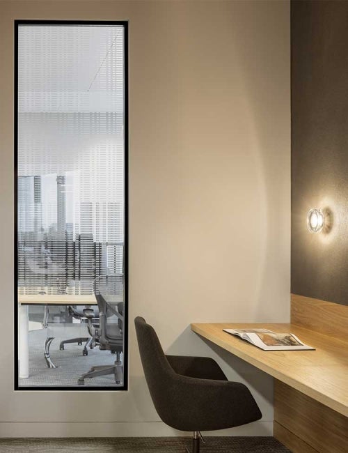 Interior of office at 22 Bishopsgate, London. Chair next to desk within quiet working area.