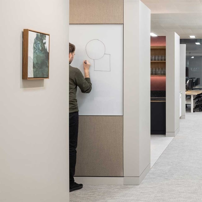 Office interior at 22 Bishopsgate, London. A man can be seen drawing on a whiteboard. 