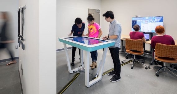 Students collaborating around center table