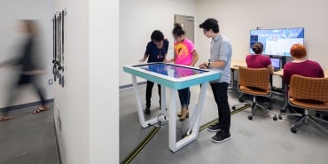 Students look at anatomage table and a table