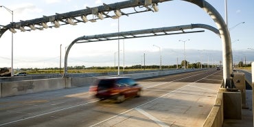 car going under toll gantries on interstate