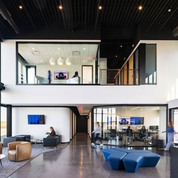 Interior of a private airport with modern furniture and a second level that holds a meeting room