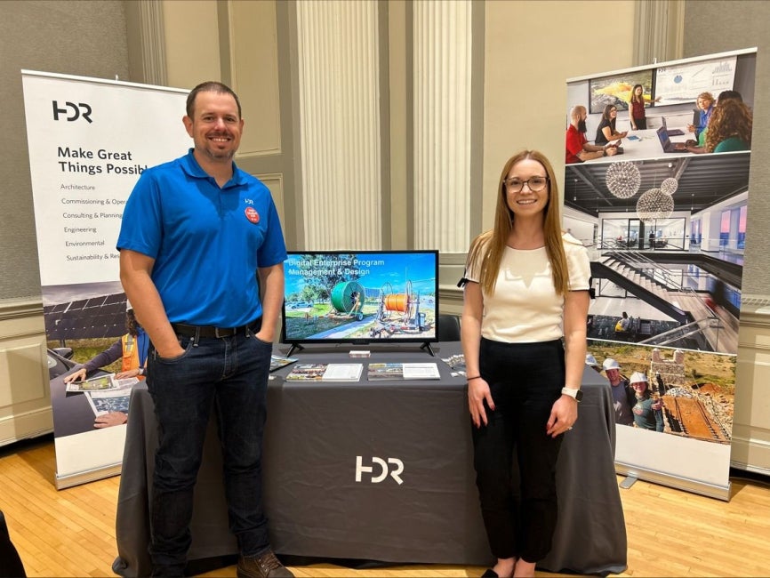 Brian Kolm and Morgan McCullough standing at booth