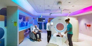 Interior of Hospital Bed and Treatment Room at The Hubbard Centre for Children. Nurse and patient with visitors in view.