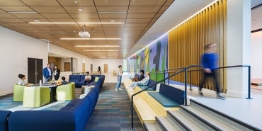 interior common room of Radius Youth Center featuring warm wood tones and bright, yet calming color accents