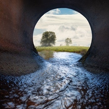 Sewer pipe with meadow in the background