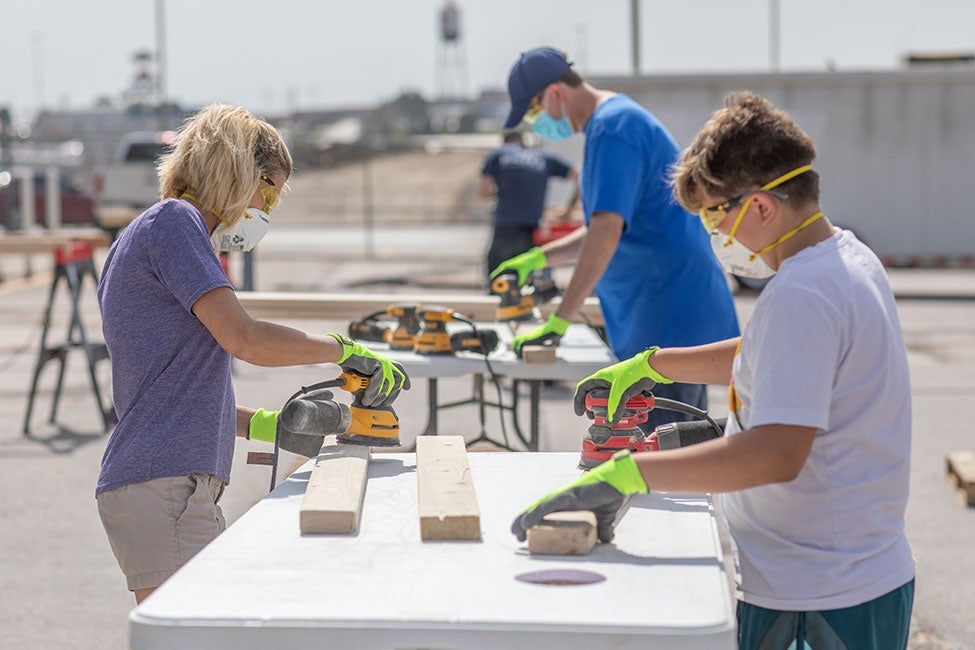 employees volunteering to build beds