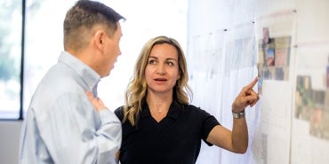 woman explaining map in project office to man