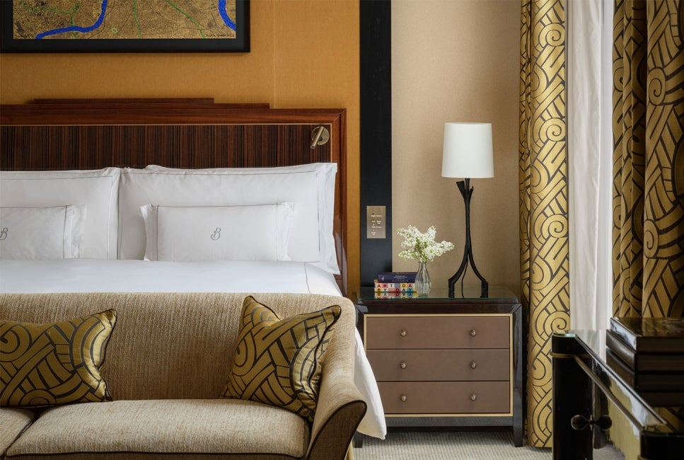 Interior of a room at The Beaumont Hotel with a dressed bed and sofa in shot.