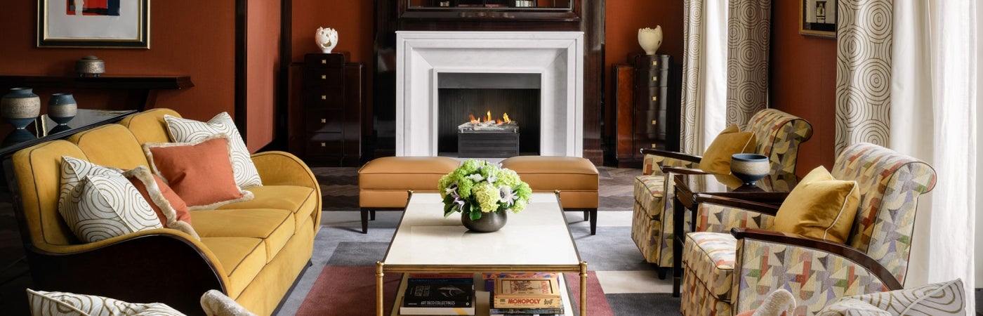 Interior of lounge area at The Beaumont Hotel, with soft furnishings and fire place in the background.