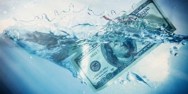 One hundred dollar bill splashing into water.