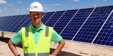 Will Kirby Standing by Solar Installation