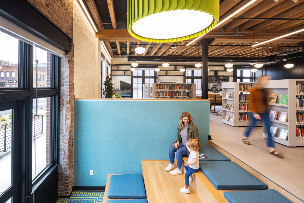 A photo of a mom and kid sitting on the active stair at the Omaha Public Library Downtown Branch