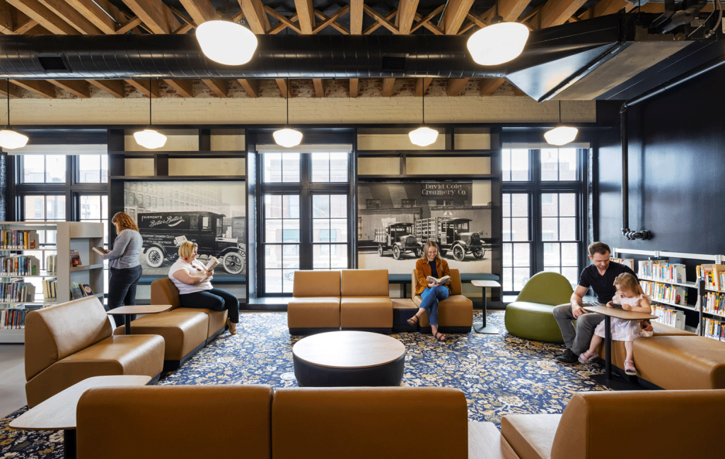 A photo of people sitting in the lower-level living room space of the Omaha Public Library Downtown Branch