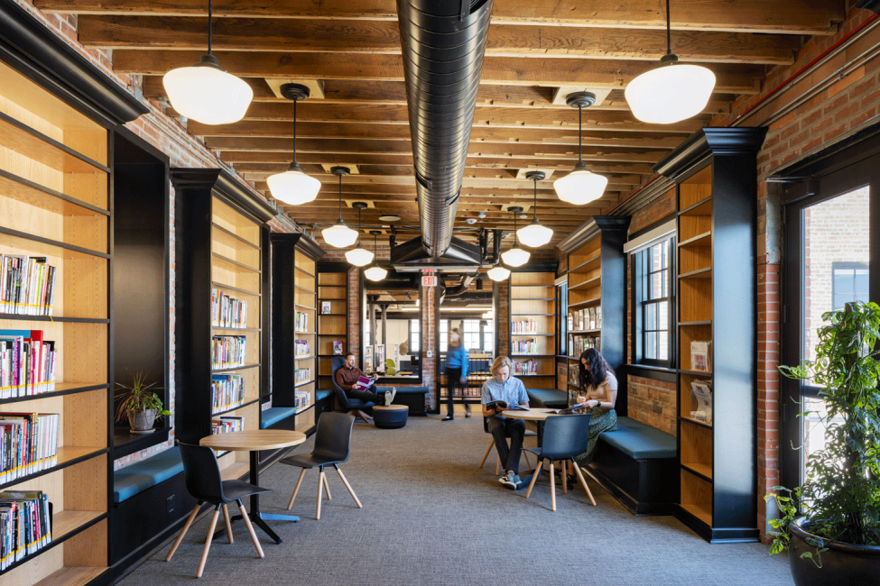 A photo of people sitting together at a table in the Omaha Public Library Downtown Branch reading room.