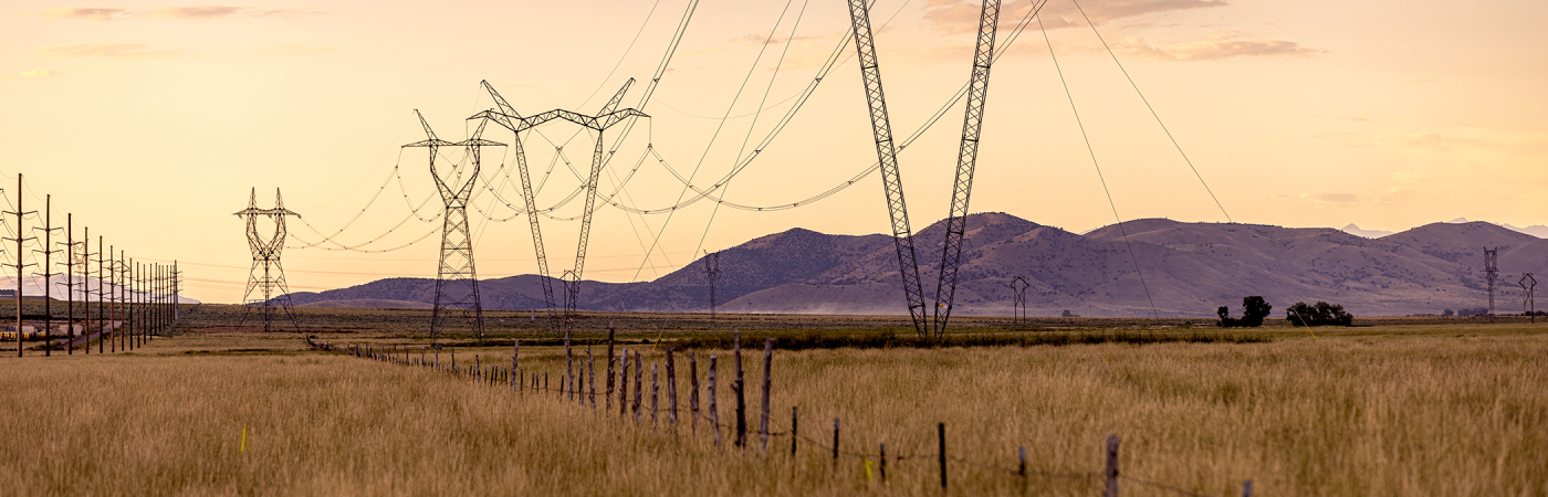 Transmission line towers in front of mountains